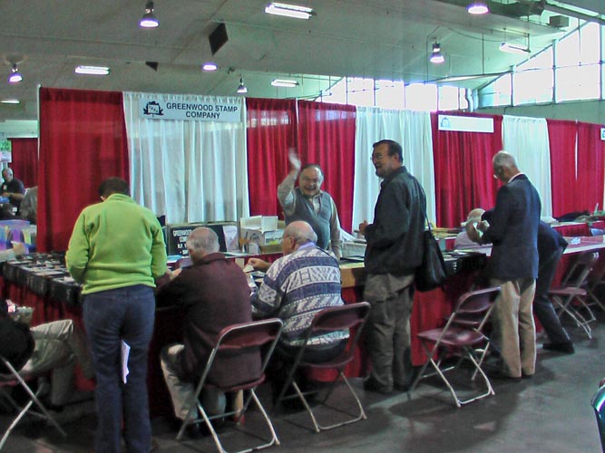 Bob Thorne waving at Hank Narbonne's table at the bourse